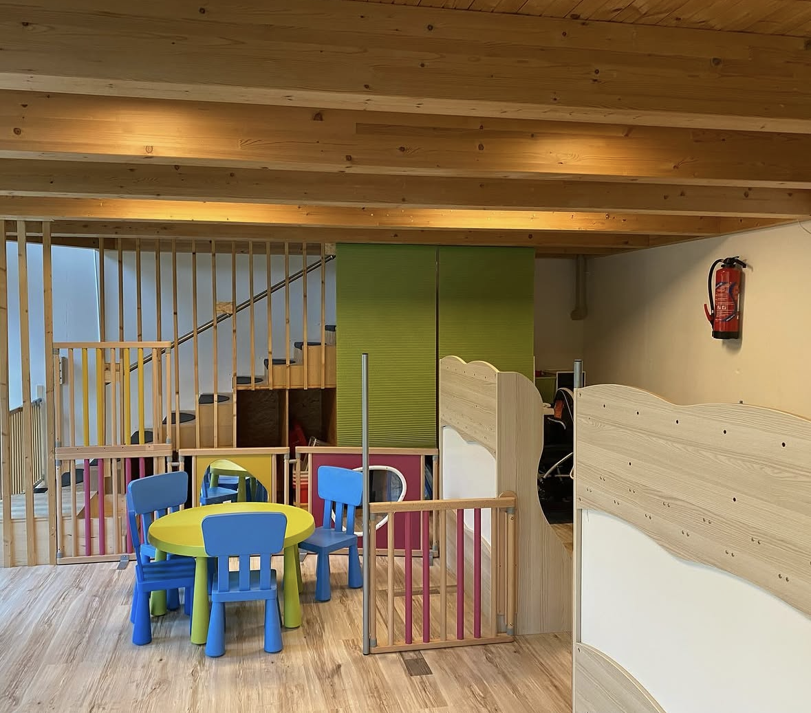 Salle d'éveil chaleureuse de la garderie Au Petit Bonheur, jouets en bois et lumière naturelle